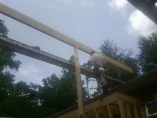 Carpenter setting a ridge beam over a new addition frame — Ice Dam Removal by Roofing Brothers in Wadena
